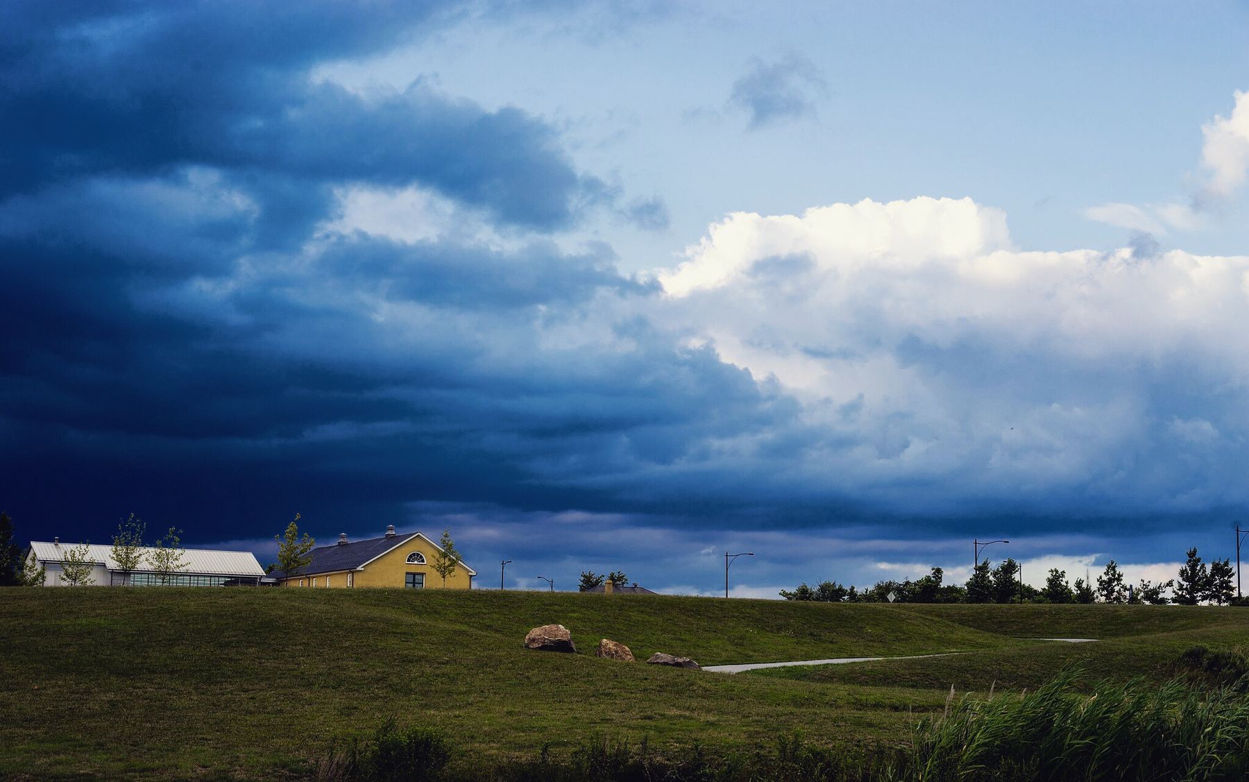 Storm clouds clearing over a grassy hill